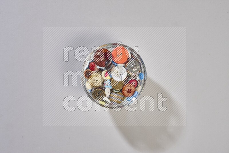 Mixed assorted buttons on grey background