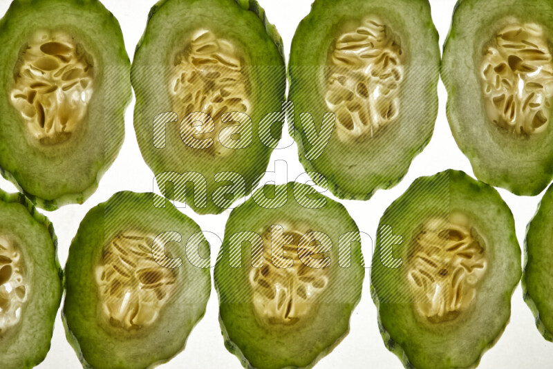 Cucumber slices on illuminated white background