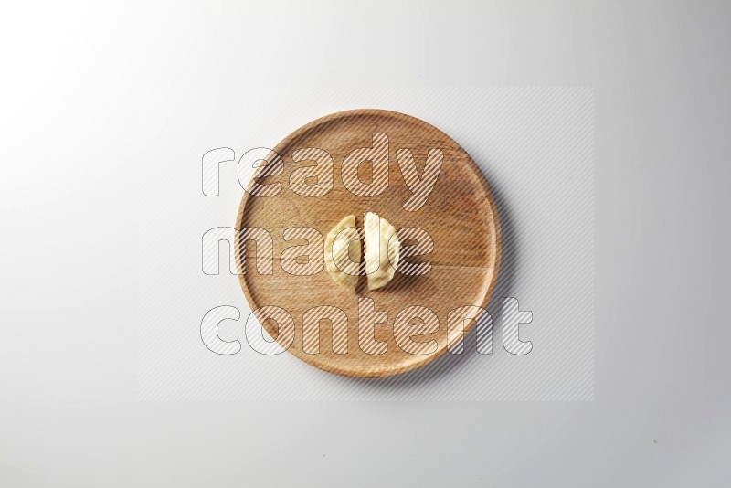 Two Sambosas on a wooden round plate on a white background