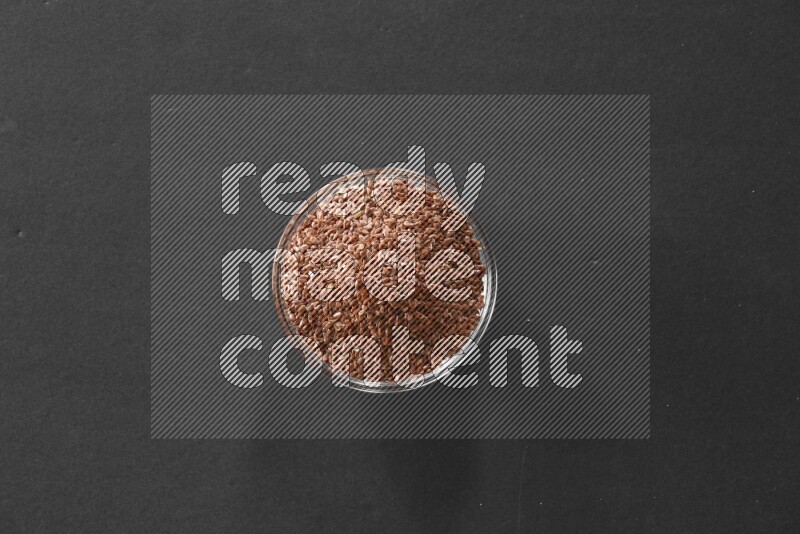 حبوب الكتان في وعاء زجاجي علي خلفية سوداء