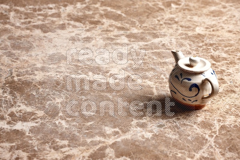 Pottery tea pot on Beige Marble Flooring, 45 degrees