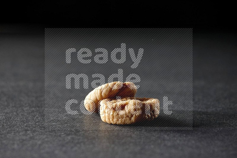 Two dried figs on a black background in different angles