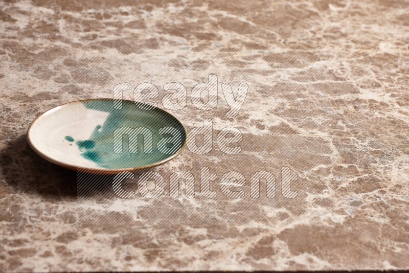 A multicolored pottery plate on beige marble background