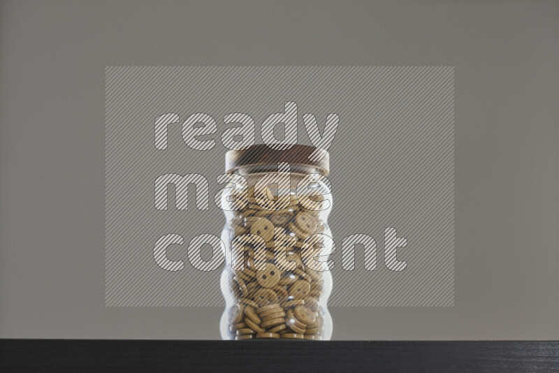 Buttons in a glass jar on black background
