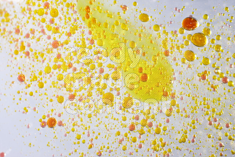 Close-ups of abstract yellow and red watercolor drops on oil Surface on white background