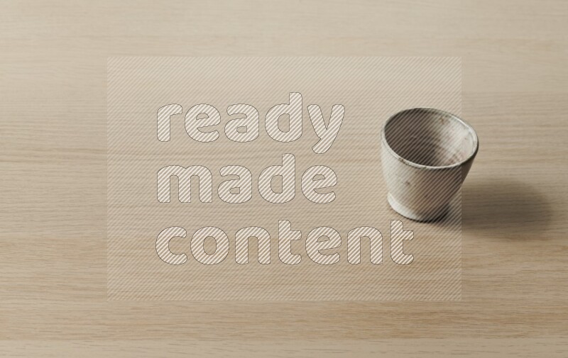 A pottery cup on light wooden background