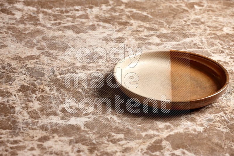 Multicolored Pottery Oven Plate on Beige Marble Flooring, 45 degrees