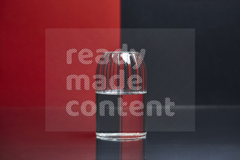 The image features a clear glassware filled with water, set against red and black background