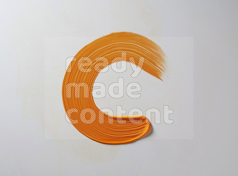 An orange circular painting brush stroke on white background