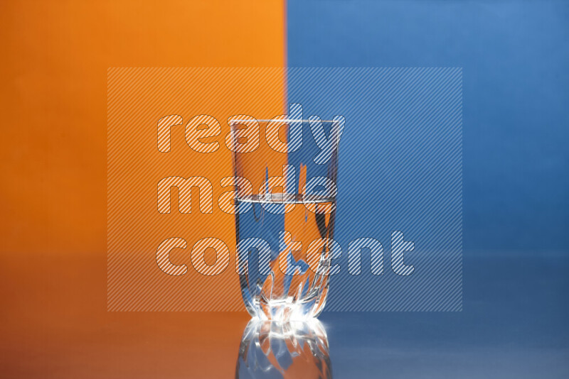 تظهر الصورة أواني زجاجية ممتلئة بالماء موضوعة على خلفية من اللونين البرتقالي والأزرق