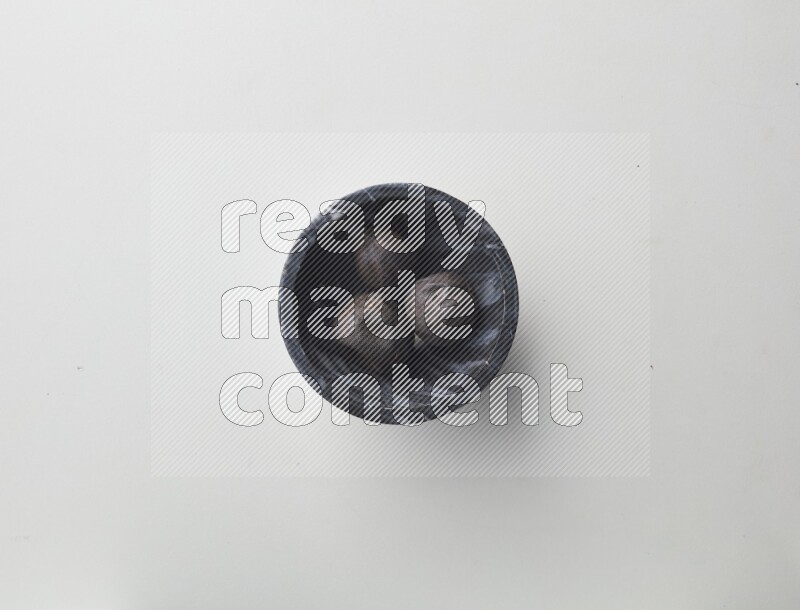 Top-view shot of dried lime (loomi) in a container on white background