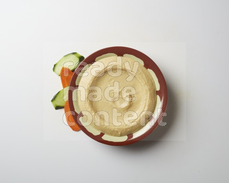 Plain hummus in a traditional plate on a white background