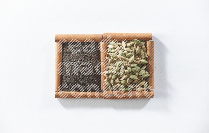 2 squares of cinnamon sticks full of black tea and cardamom on white flooring