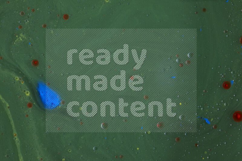 تلتقط الصورة تناثرا للطلاء الأصفر والأحمر والأزرق علي خلفية خضراء