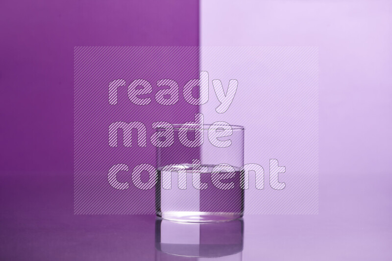 The image features a clear glassware filled with water, set against purple and light purple background