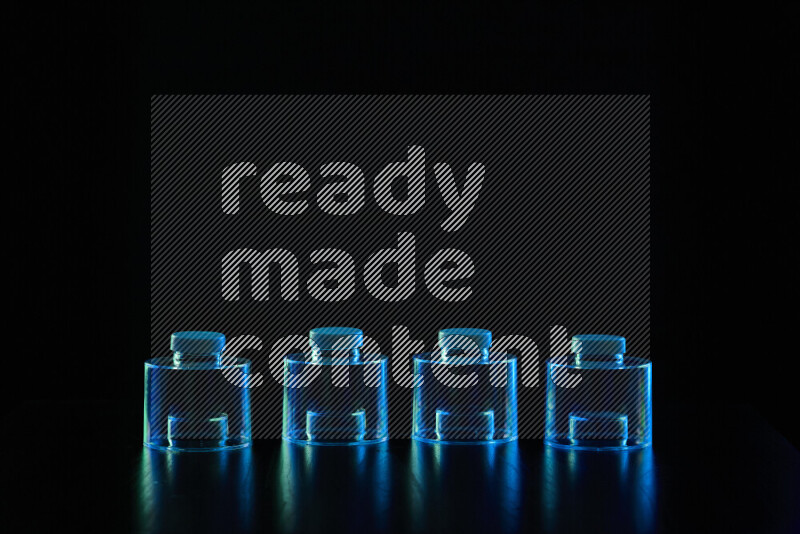 Glassware with rim light in blue and green against black background