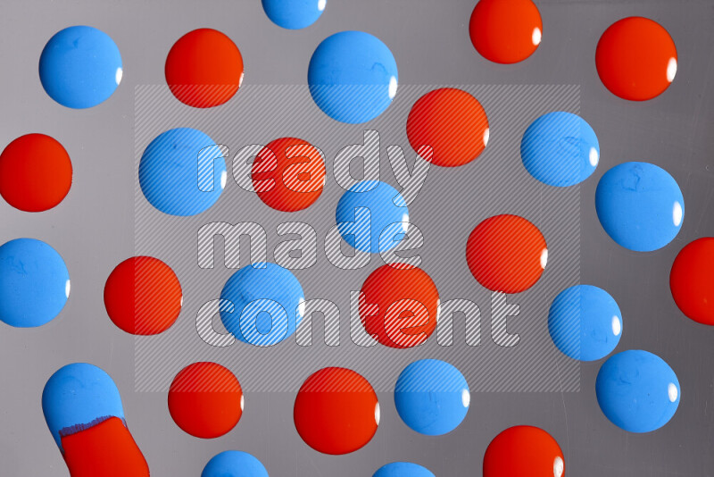 Close-ups of abstract red and blue paint droplets on the surface