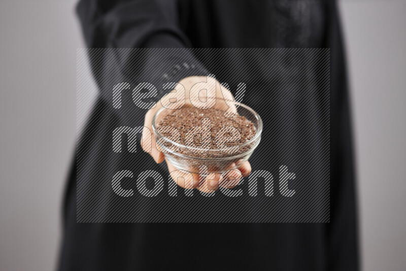 Woman in abaya holding different kinds of spices in different positions