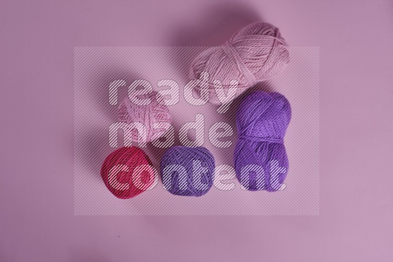 مجموعة من أدوات الخياطة والتفصيل أرجوانية وزهرية اللون على خلفية زهرية