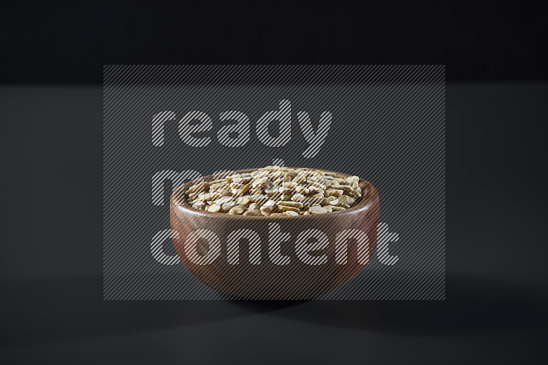 Crushed beans in a wooden bowl on grey background