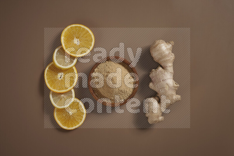 Fresh ginger root with different ingredients such as lemon, orange, honey, ground ginger on beige baackground