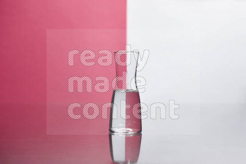 The image features a clear glassware filled with water, set against white and pink background