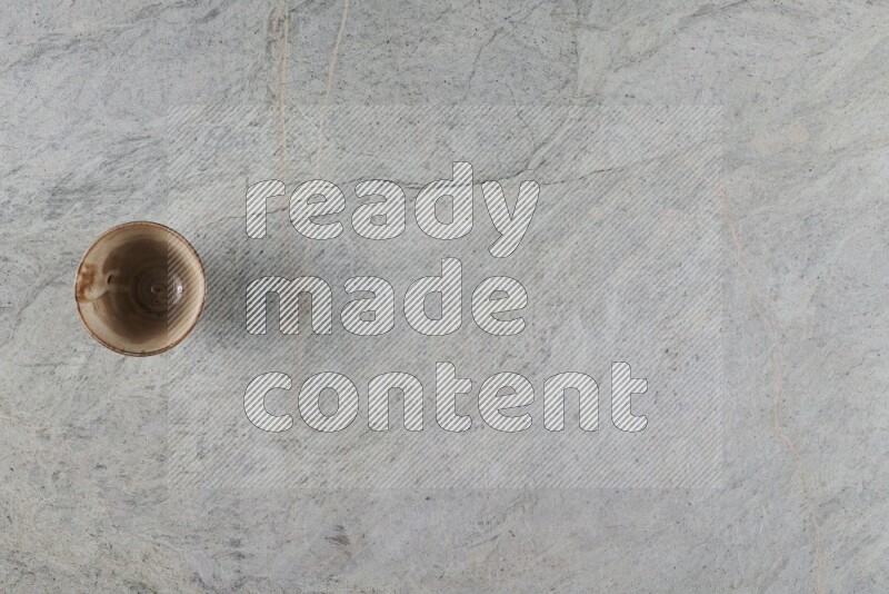 A multicolored pottery Cup on grey marble background