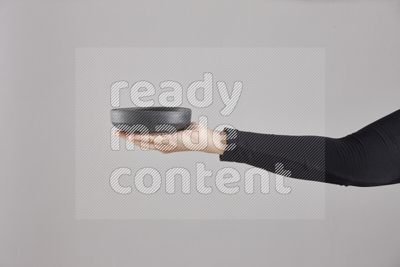 امرأة ترتدي عباءة سوداء تحمل أدوات فخارية مختلفة في أوضاع متعددة