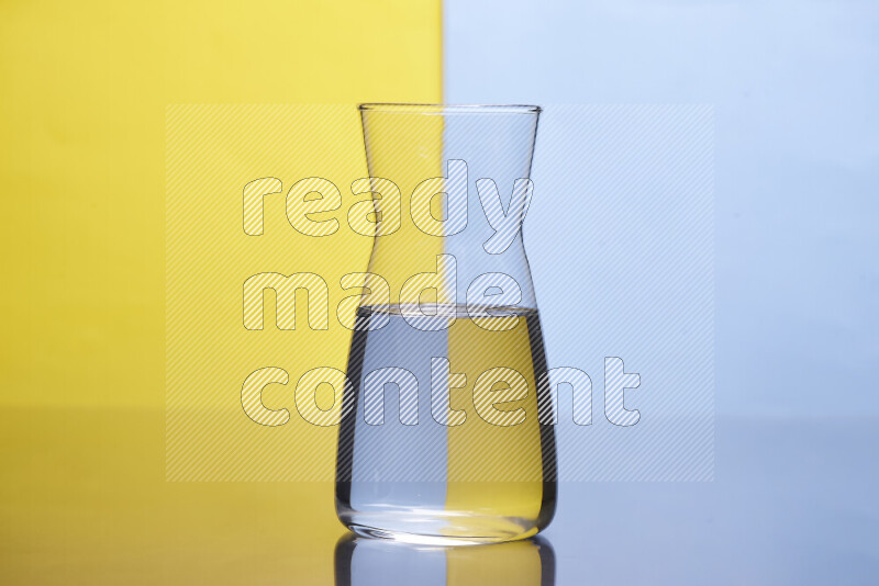 تظهر الصورة أواني زجاجية ممتلئة بالماء موضوعة على خلفية من اللونين الأصفر والأزرق الفاتح