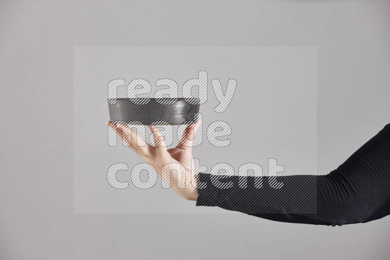 A woman in black abaya holding different pottery essentials in different positions