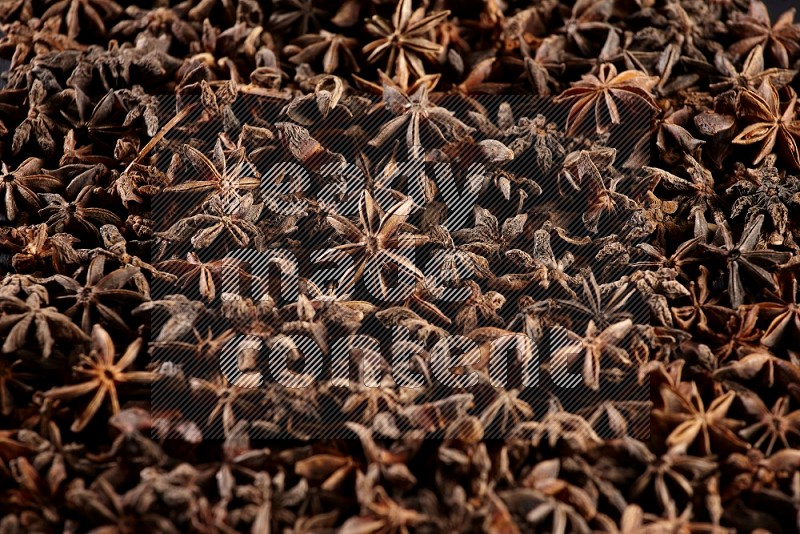 Star Anise herbs fill the frame on black flooring