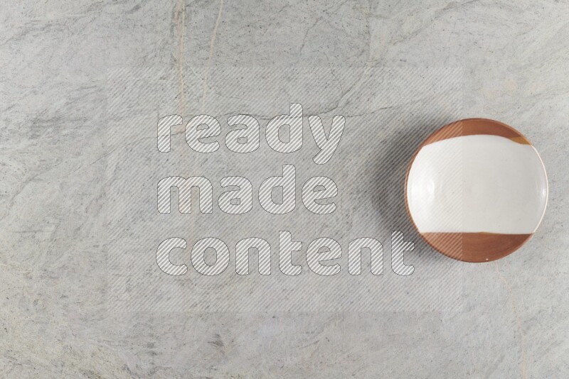 A multicolored pottery plate on grey marble background