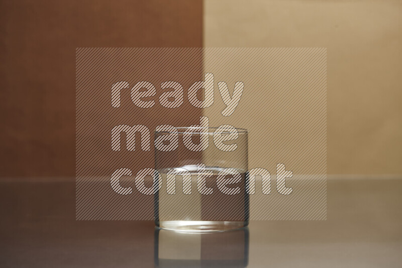 The image features a clear glassware filled with water, set against brown and light brown background