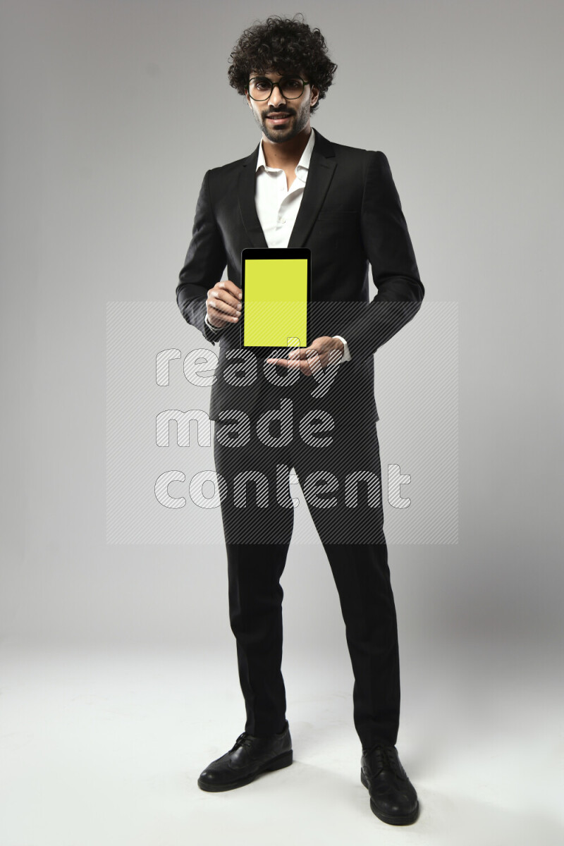 A man wearing formal standing and showing a tablet screen on white background
