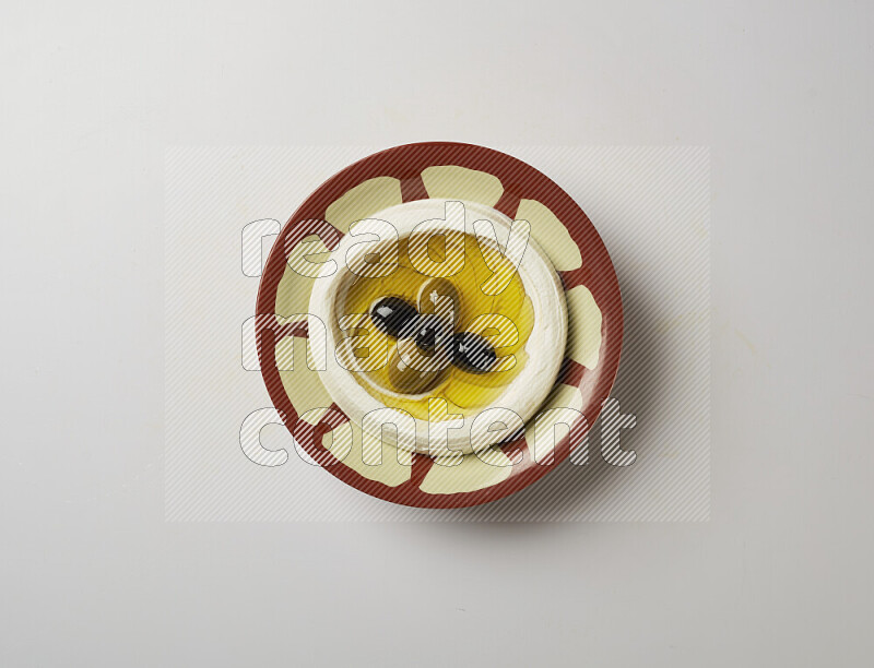 Lebnah garnished with olives in a traditional plate on a white background