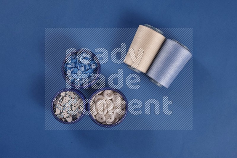 White sewing supplies on blue background