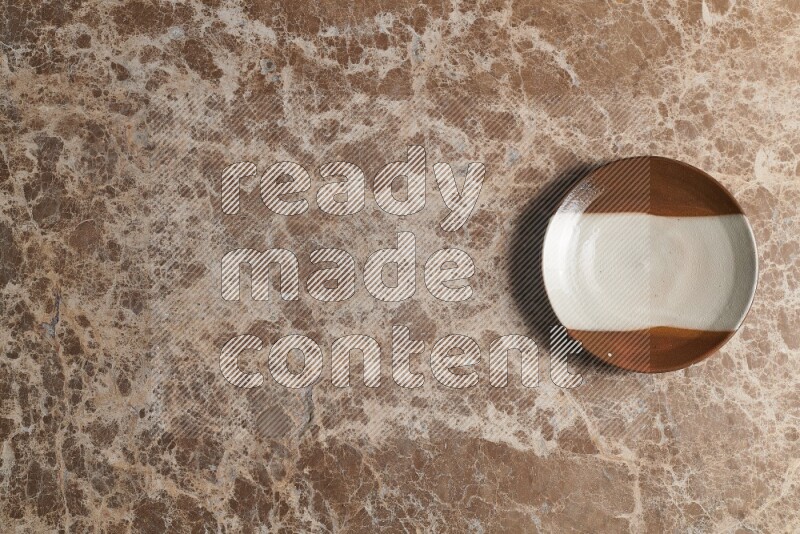 A decorative pottery plate on beige marble background