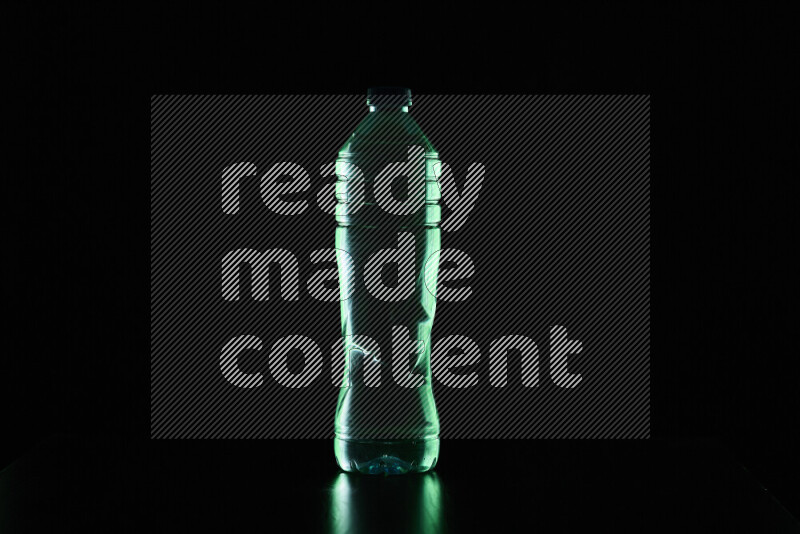 Water bottle with colored rim light against black background