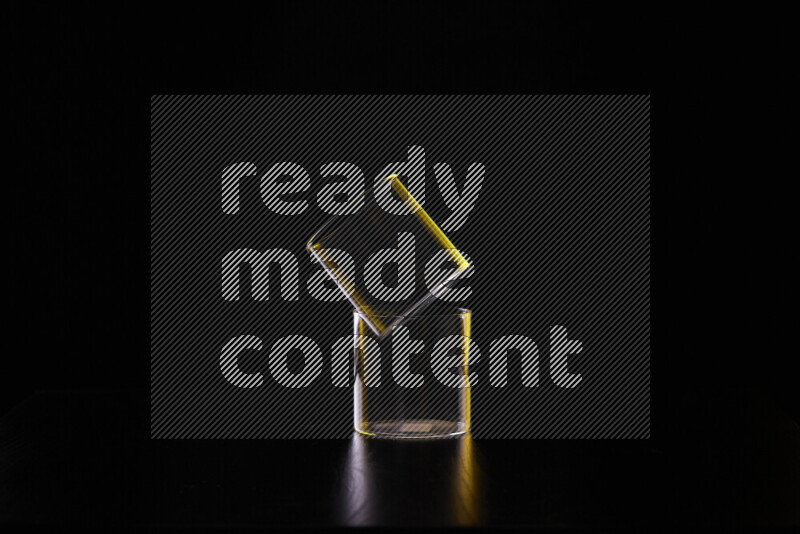 Glassware with rim light in yellow and white against black background