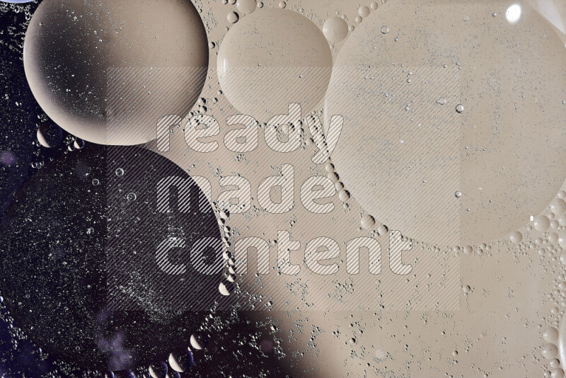 لقطات مقربة لفقاعات من الزيت على سطح الماء باللون الأسود والبيج