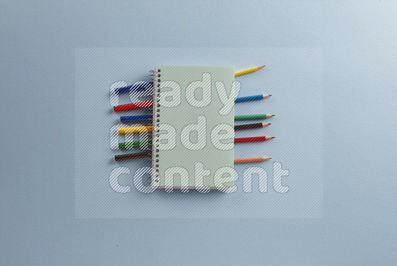 A blue notebook with school supplies on blue background (Back to school)