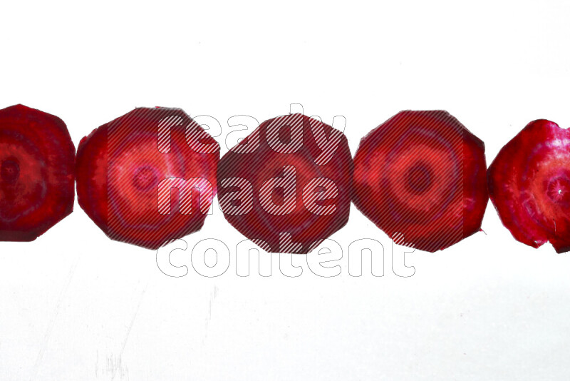 Beet slices on illuminated white background