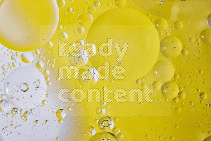 Close-ups of abstract oil bubbles on water surface in shades of white and yellow