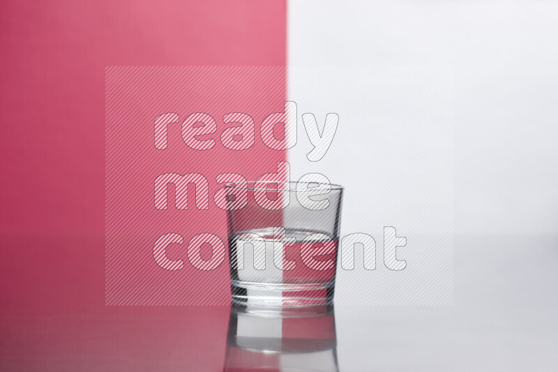 The image features a clear glassware filled with water, set against white and pink background