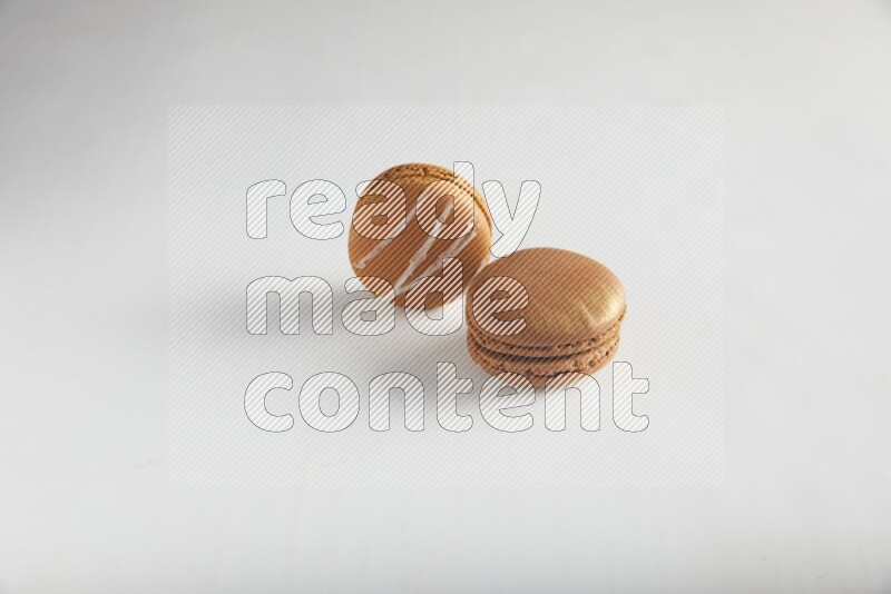 45º Shot of of two assorted Brown Irish Cream, and Brown Coffee macarons  on white background