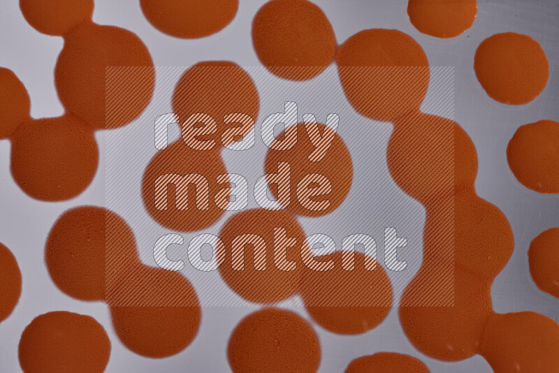 Close-ups of abstract orange paint droplets on the surface