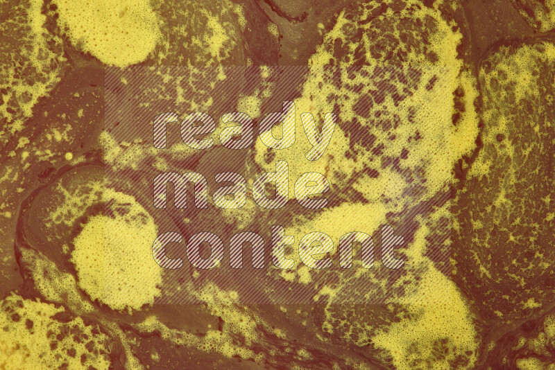 The image depicts a marbling effect with swirling patterns of red and yellow