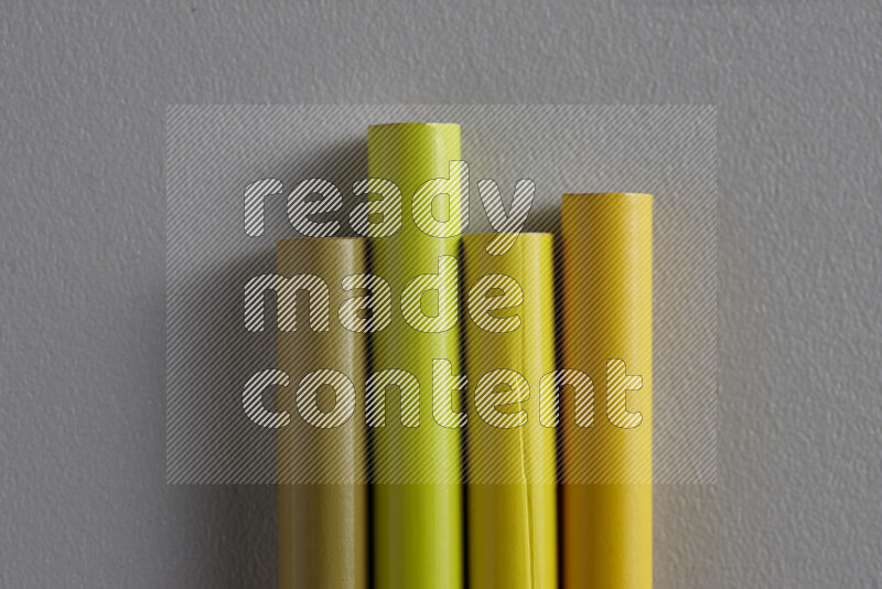 مجموعة من أقلام الرصاص الملونة مرتبة لتعرض تدرجا من الألوان الصفراء علي خلفية رمادية