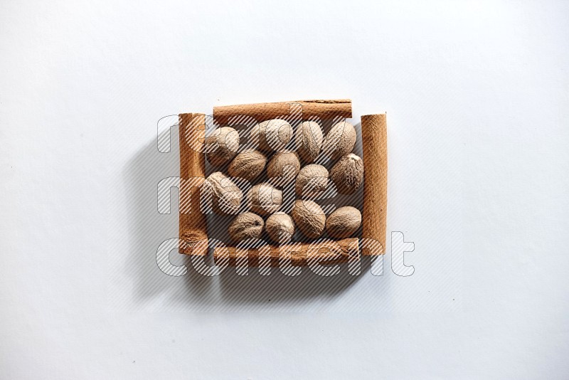 A single square of cinnamon sticks full of nutmeg on white flooring
