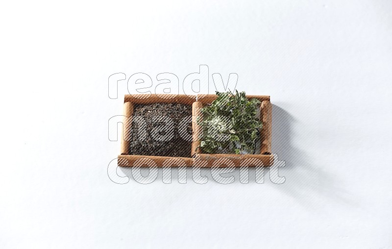 2 squares of cinnamon sticks full of black tea and dried mint leaves on white flooring